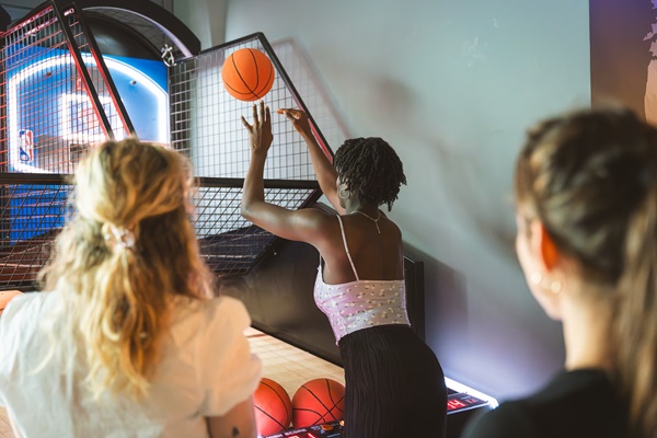 Friends play basketball at Boom