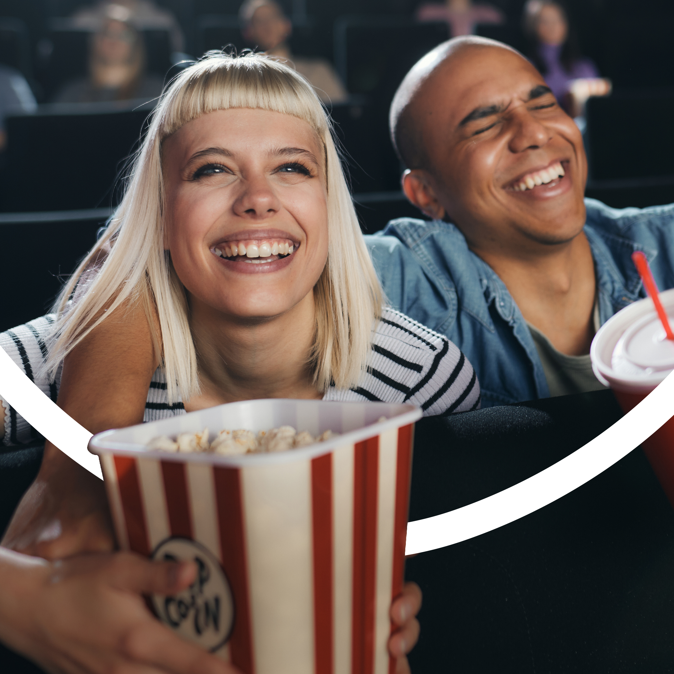 A couple at the cinema with popcorn smiling