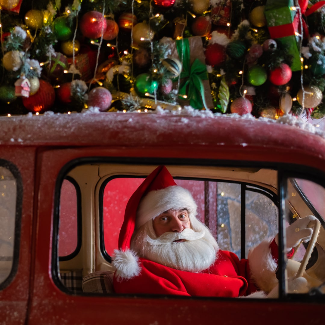 Santa Claus in red car looking out the window