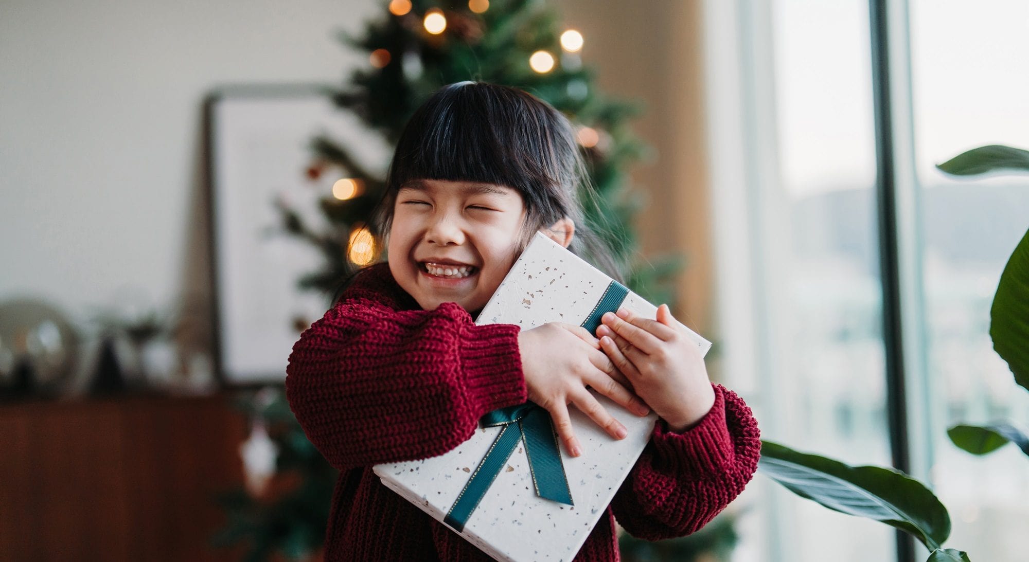 Young girl smiling holding a christmas present