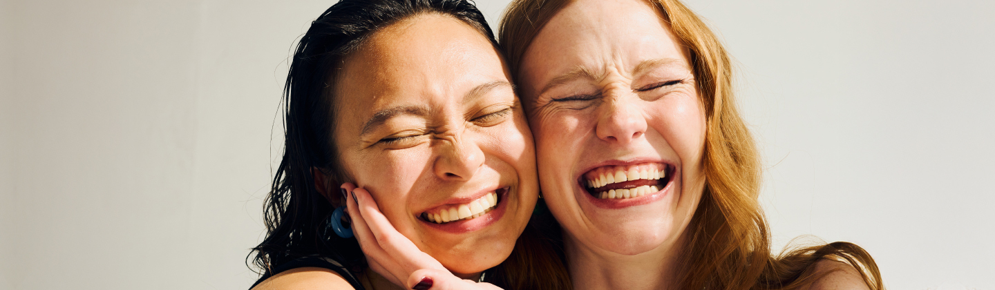 Two friends smile together.