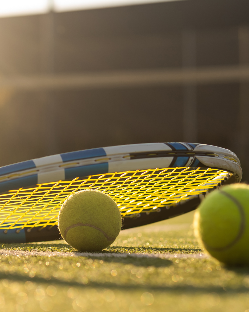 Tennis racket with ball on grass court floor