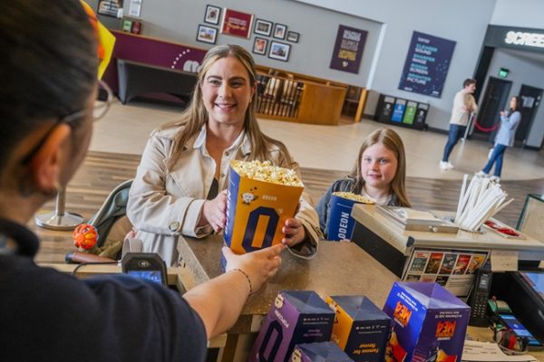 A mum and daughter buy popcorn in the ODEON cinema.