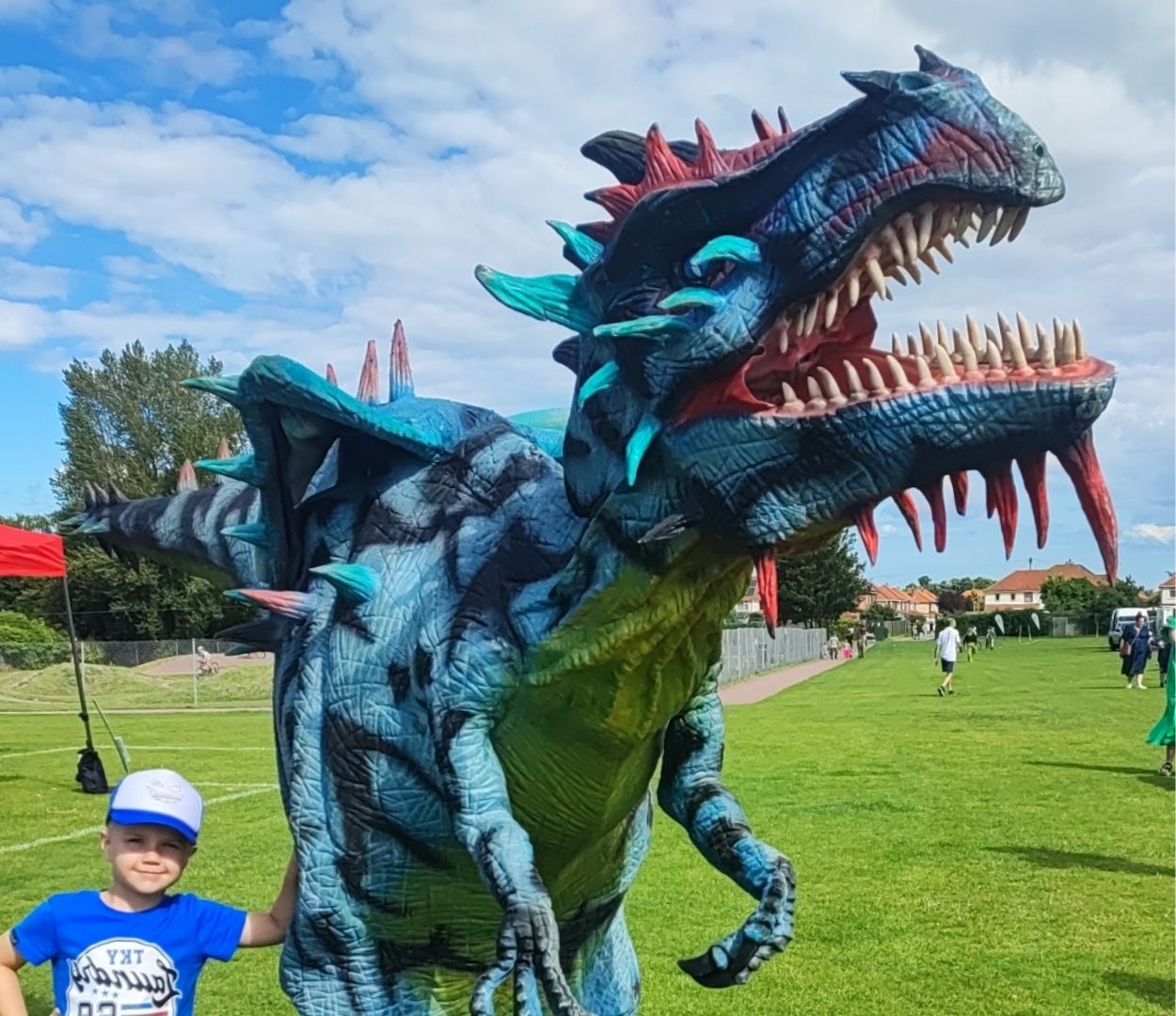 A dragon character puppet walking around outdoors