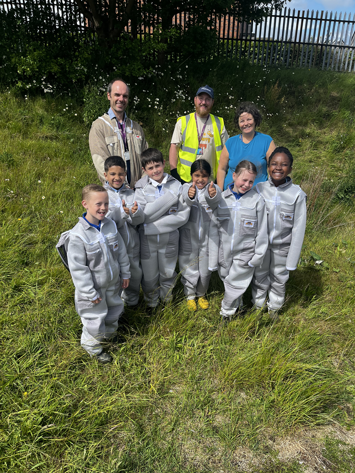 A group of children in beekeeping outfits