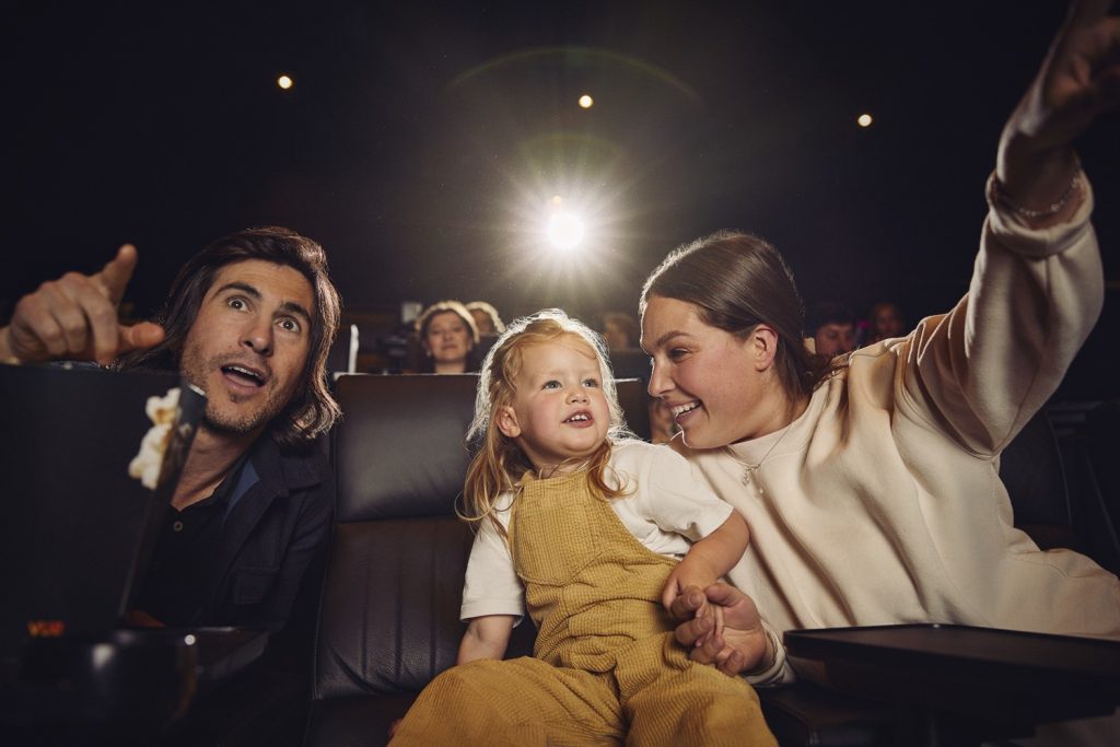 A mum dad and toddler watch a film at Vue