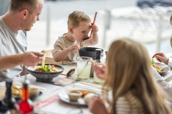 A young boy slurps soup at wagamama