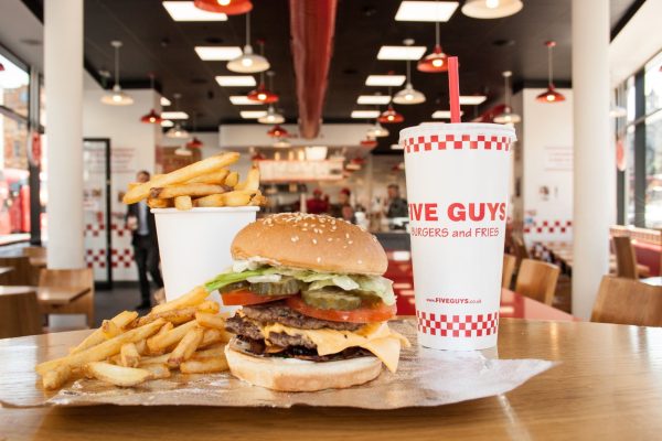 A five guys burger meal with fries and a drink.