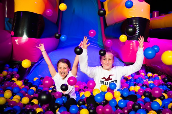 Two young people play in a ball pool at AirHaus.