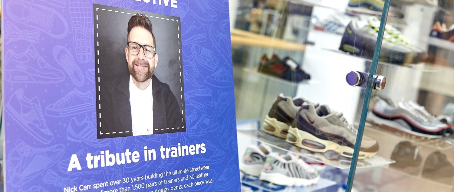The trainer collection next to a sign showing the portrait of Nick and information about the exhibition.