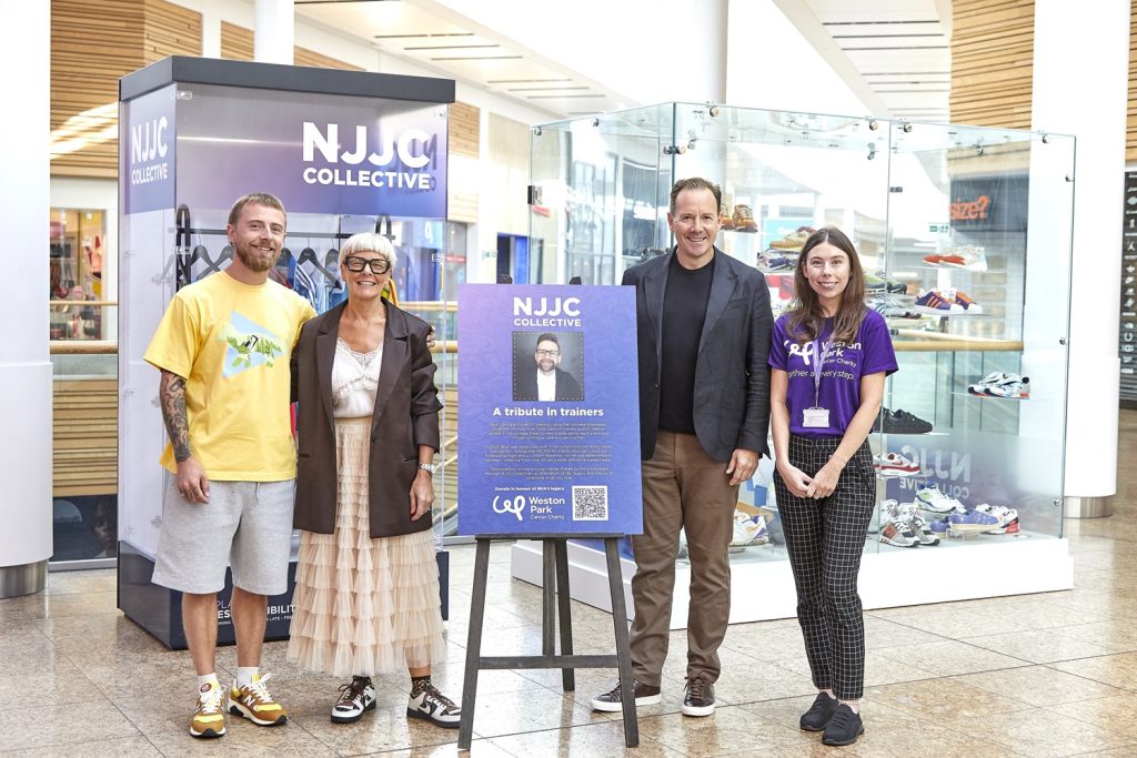 A group of Nick's family and supporters from Meadowhall and Weston Park stand next to the trainer exhibition.