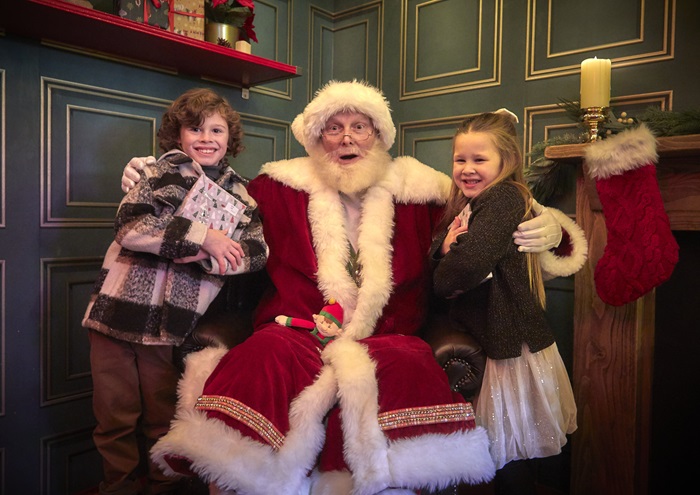 Santa smiles with two children in his grotto at Meadowhall.
