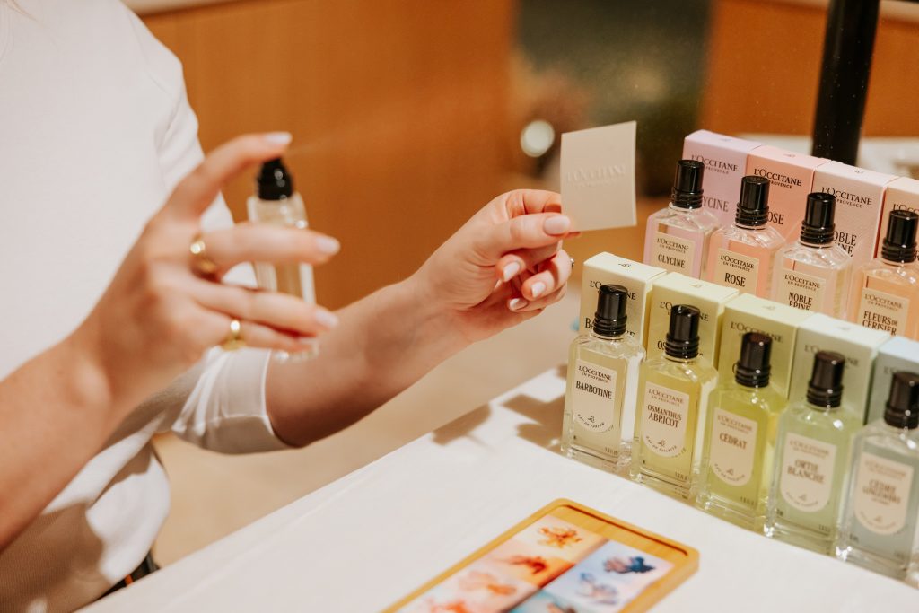 Lady spraying perfume onto a tester card