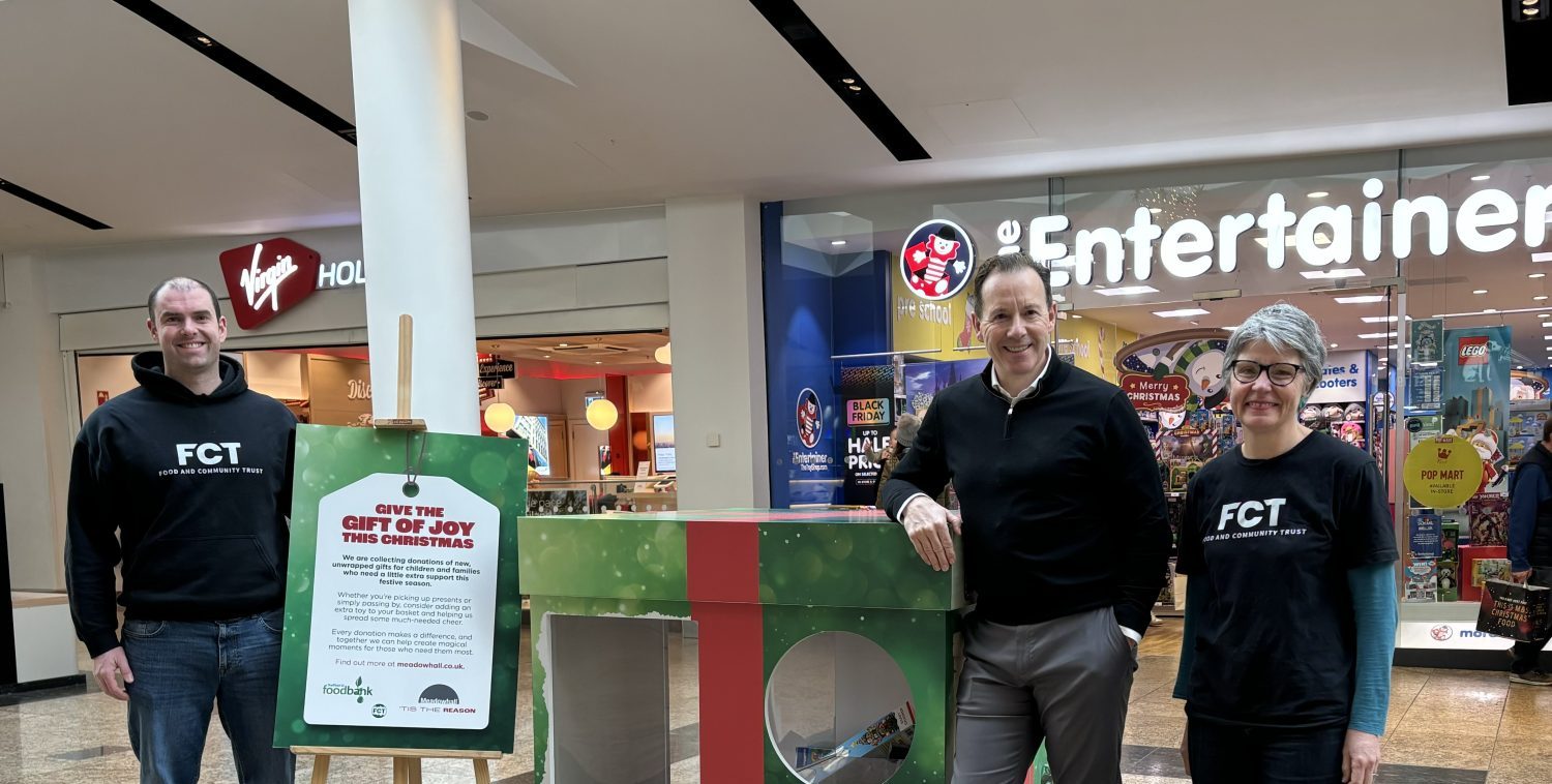 A group of people around the toy donation box in Meadowhall.