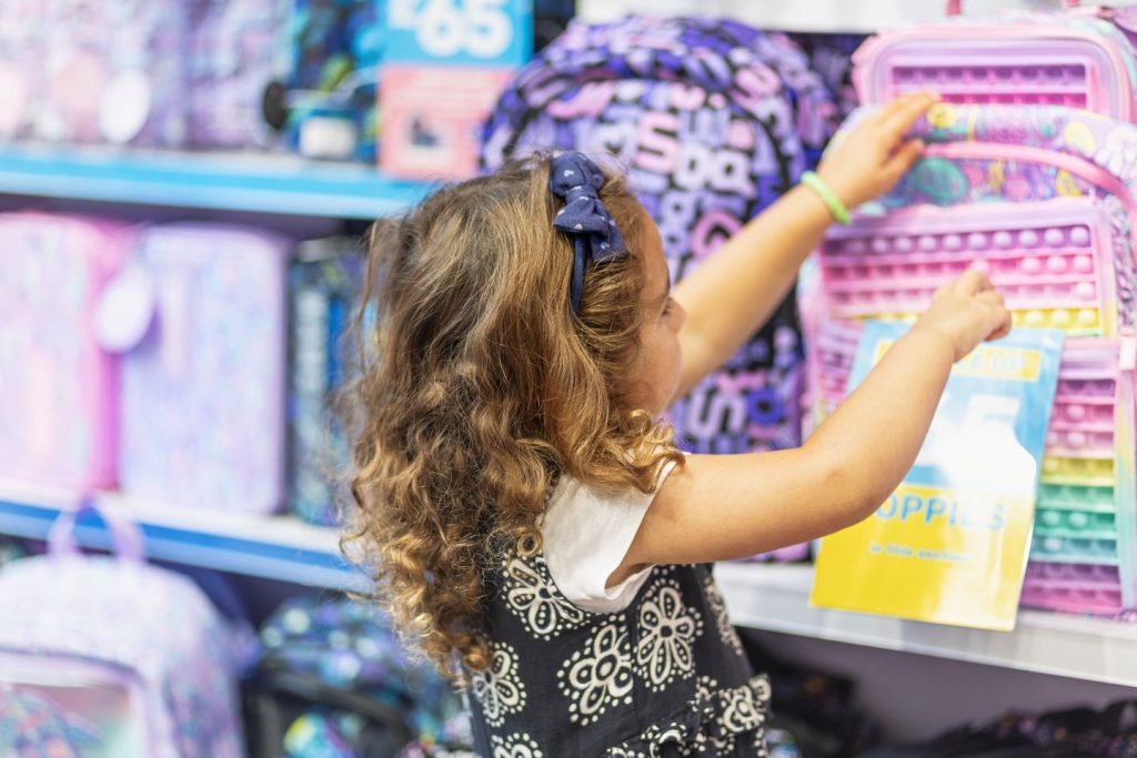 A young girl selects a backpack in Smiggle