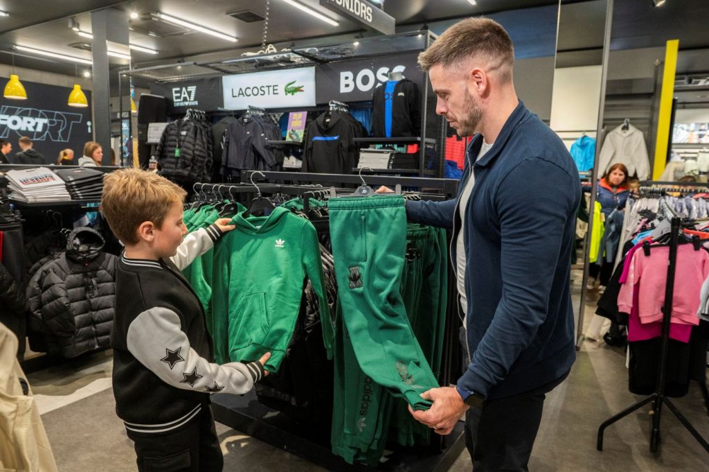 Father and son shopping for school sportswear