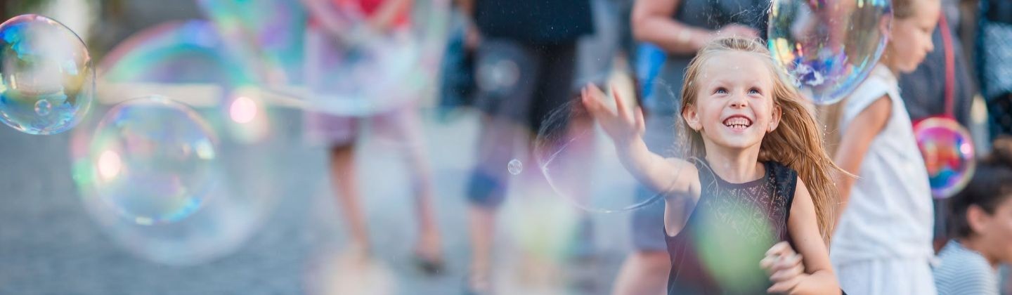 Child playing with giant bubbles