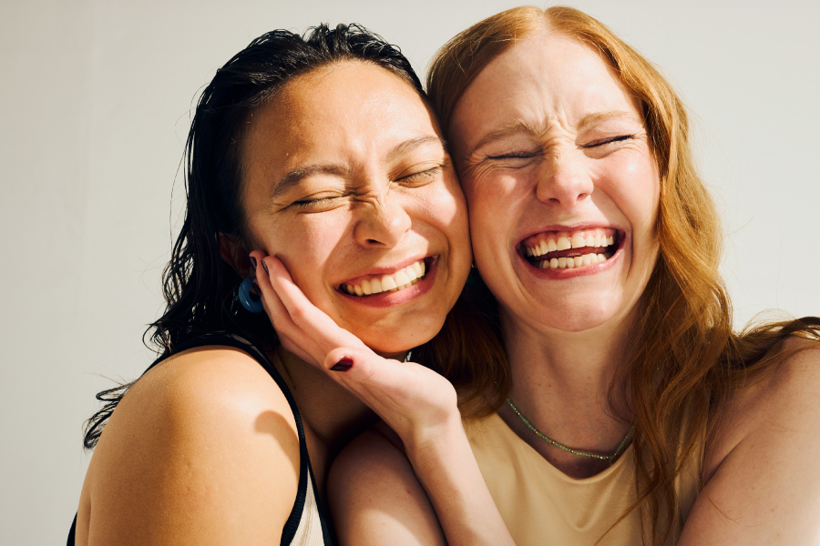 Two friends smile together.