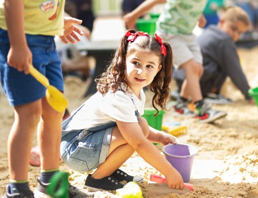 A child plays in the sand pit