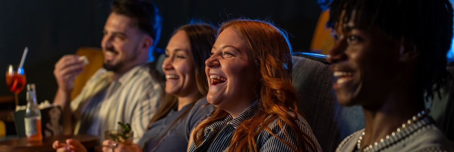 Friends watch a film together at the cinema.