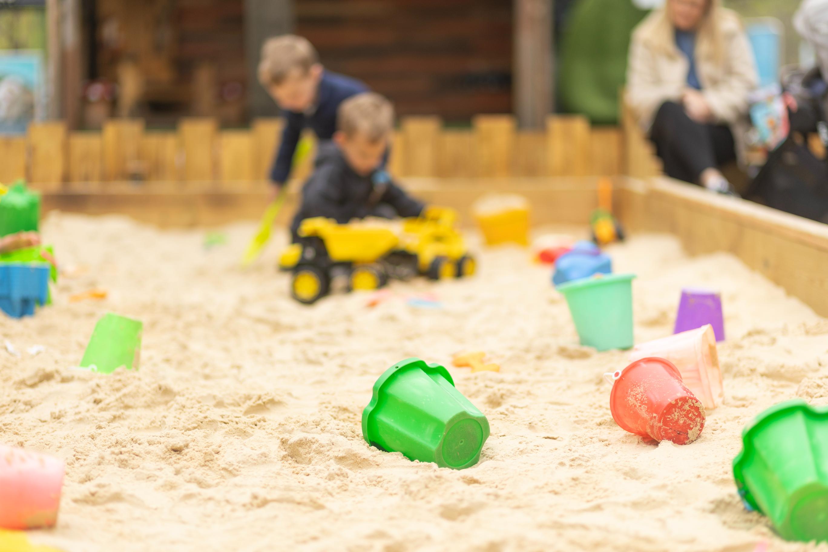 Two boys playing in sand pitt