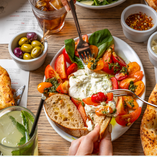 A salad bowl with bread, burrata and tomatoes